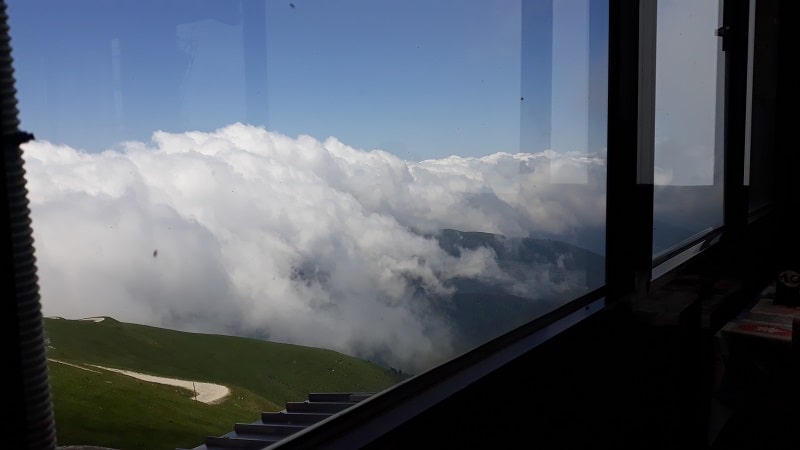 Da dentro, sulla Valbelluna coperta di nuvole. La strada in basso a sinistra è quella che sale dalla forcella Zoppei.