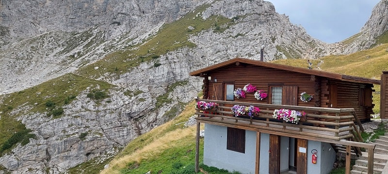 La parte posteriore del rifugio. In alto a destra si vede la forcella oltre la quale si trova il lago.